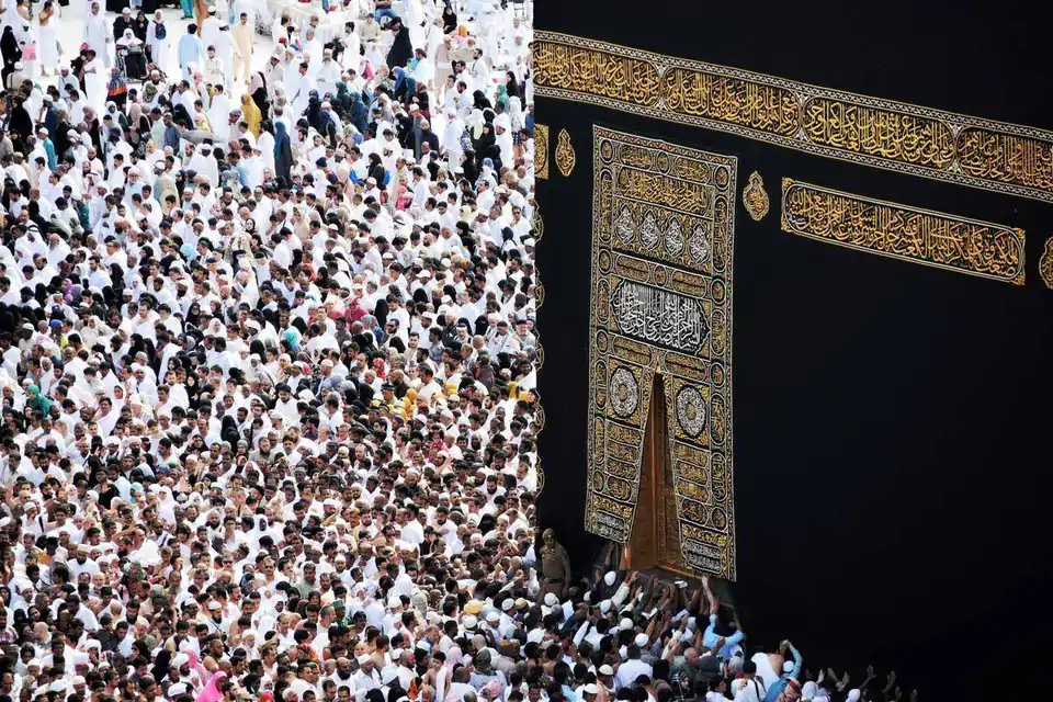 De gouden deur van de Kaaba met pelgrims in wit ihraam