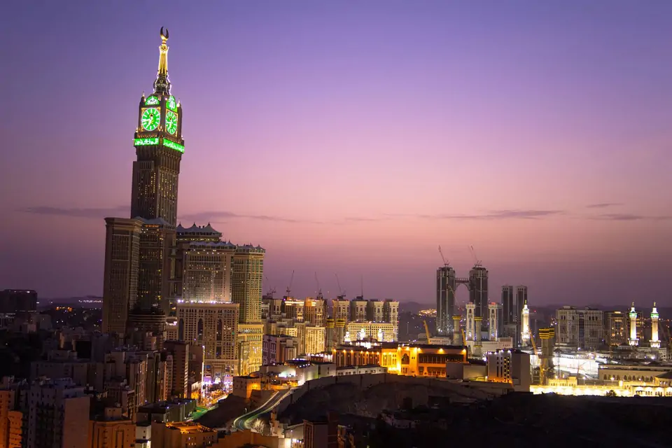 Skyline van Mekka in de avond met de verlichte kloktoren